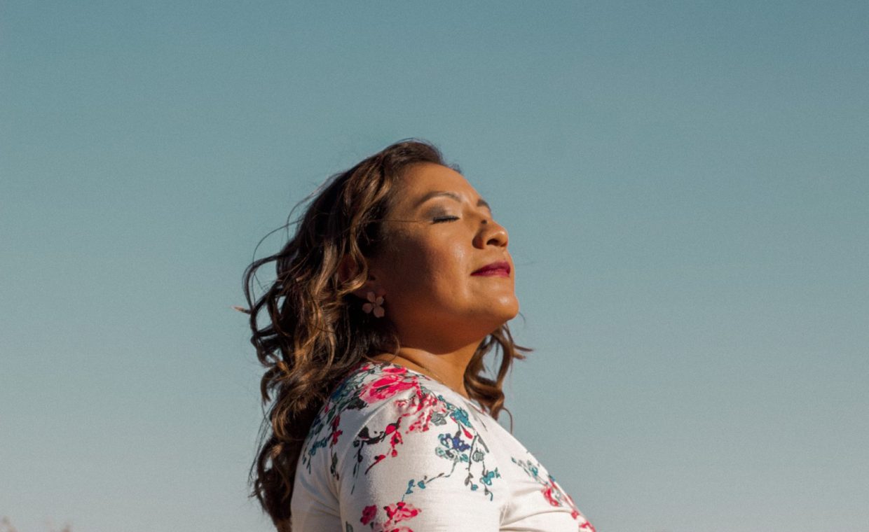 Side profile of a woman enjoying the sun outdoors, exuding calmness and confidence.