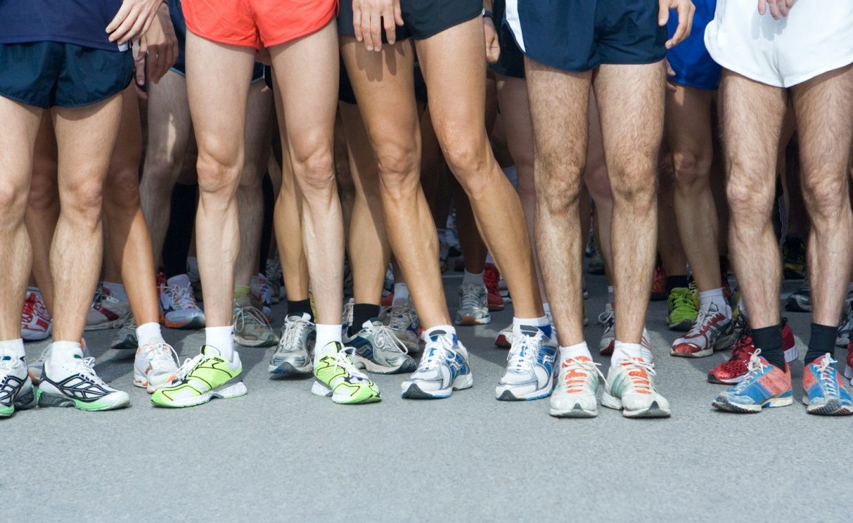man in blue shorts and white nike sneakers