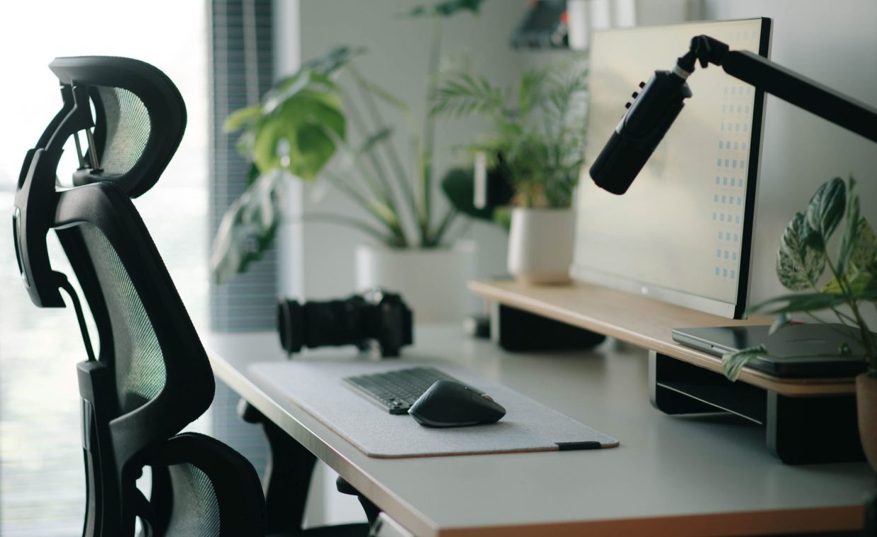 Stylish home office setup with ergonomic chair, plants, and tech accessories creating a modern work environment.